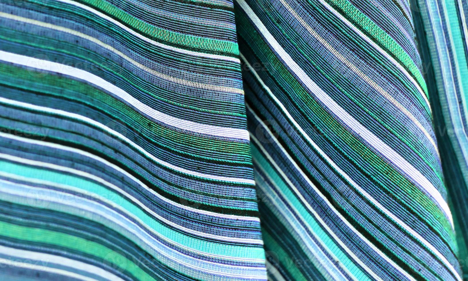 Detailed close up view on samples of cloth and fabrics in different colors found at a fabrics market photo