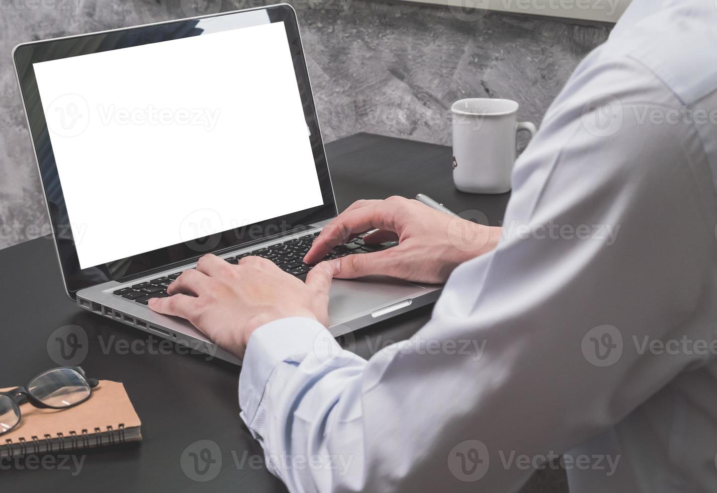 Close up of Businessman working on Laptop on the black desk. photo