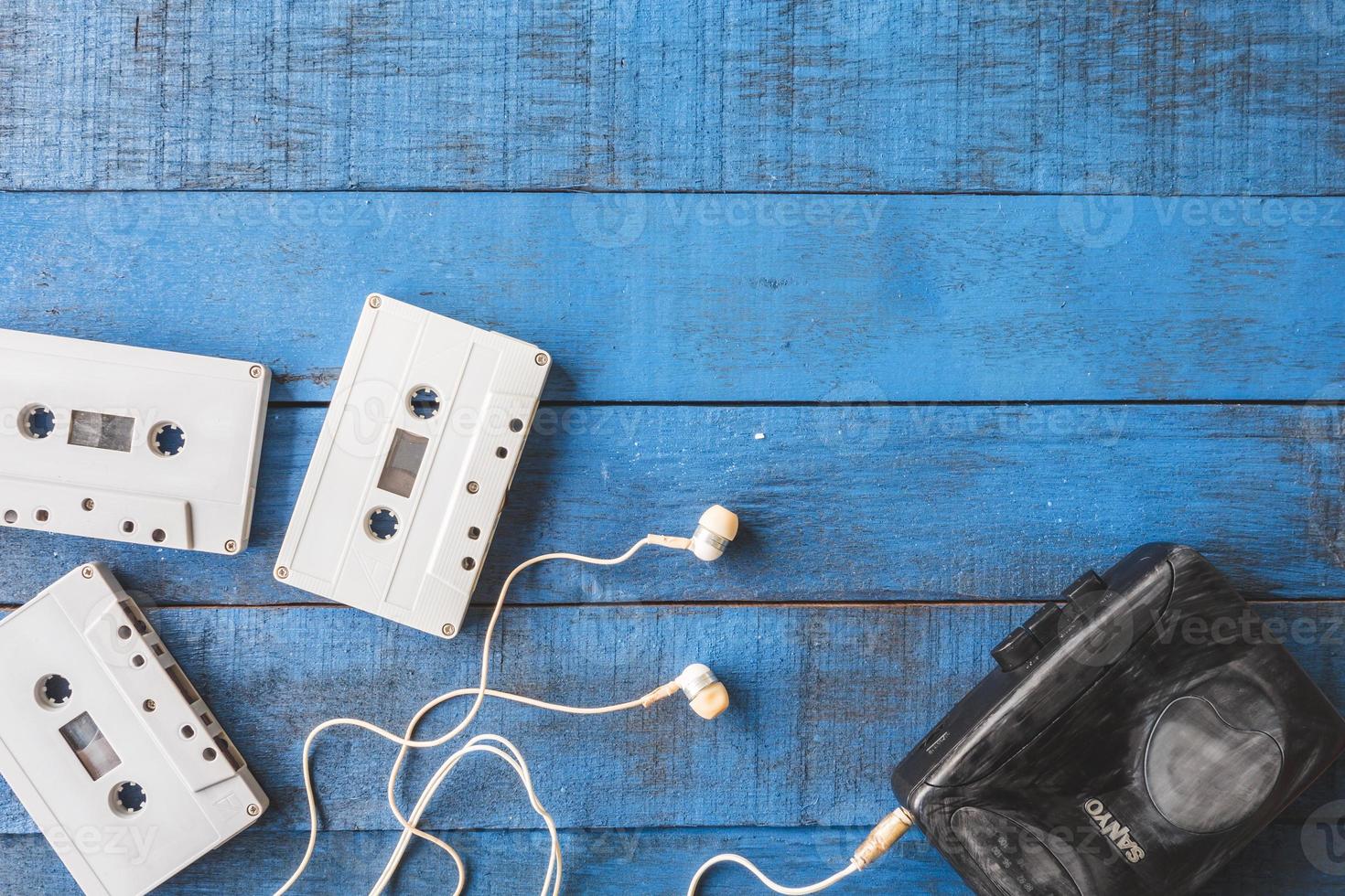 vista superior del reproductor de cassette con cinta de audio sobre fondo de mesa de madera azul, espacio libre para texto foto