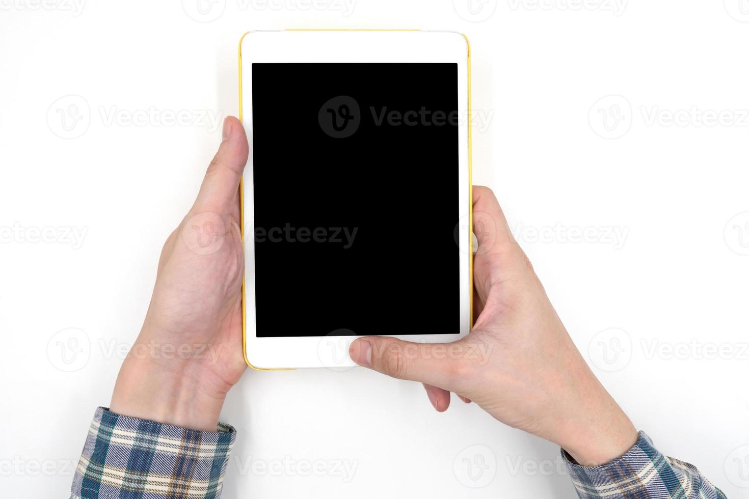 Male hands holding a white tablet touch computer gadget with touch blank black screen on white background. photo