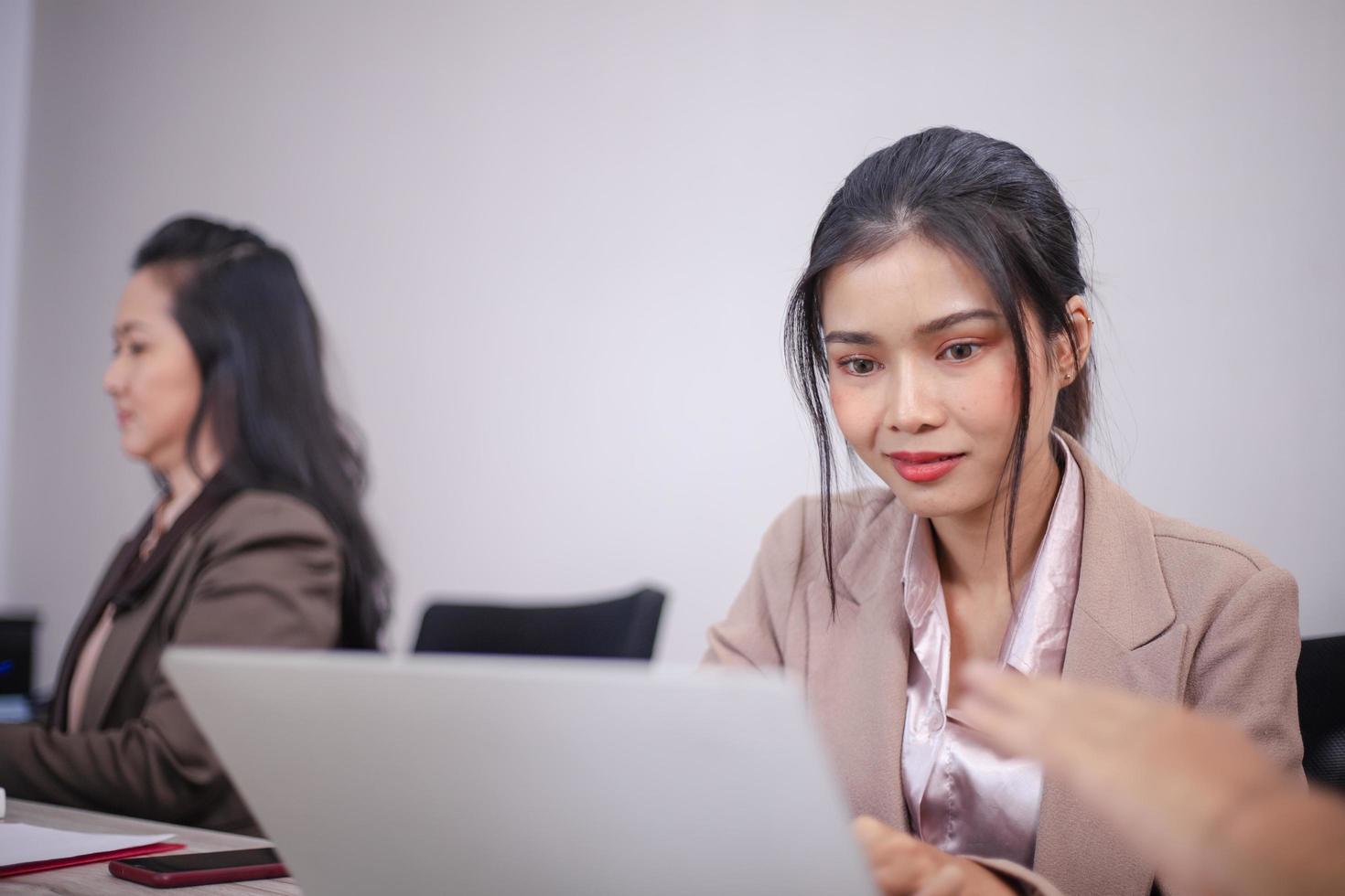 Concentrated multiethnic coworker busy using laptop brainstorm sharing thoughts at office meeting photo