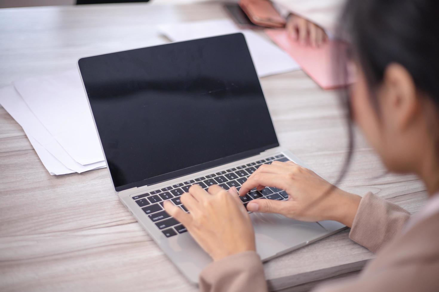 Concentrated multiethnic coworker busy using laptop brainstorm sharing thoughts at office meeting photo