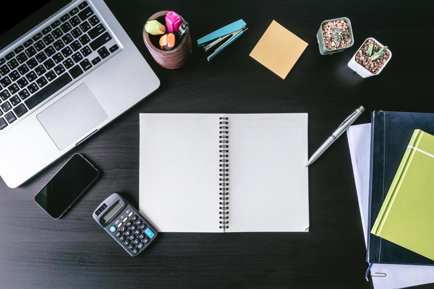 Top view of  Blank notebook with Laptop and office supplies on the desk. photo