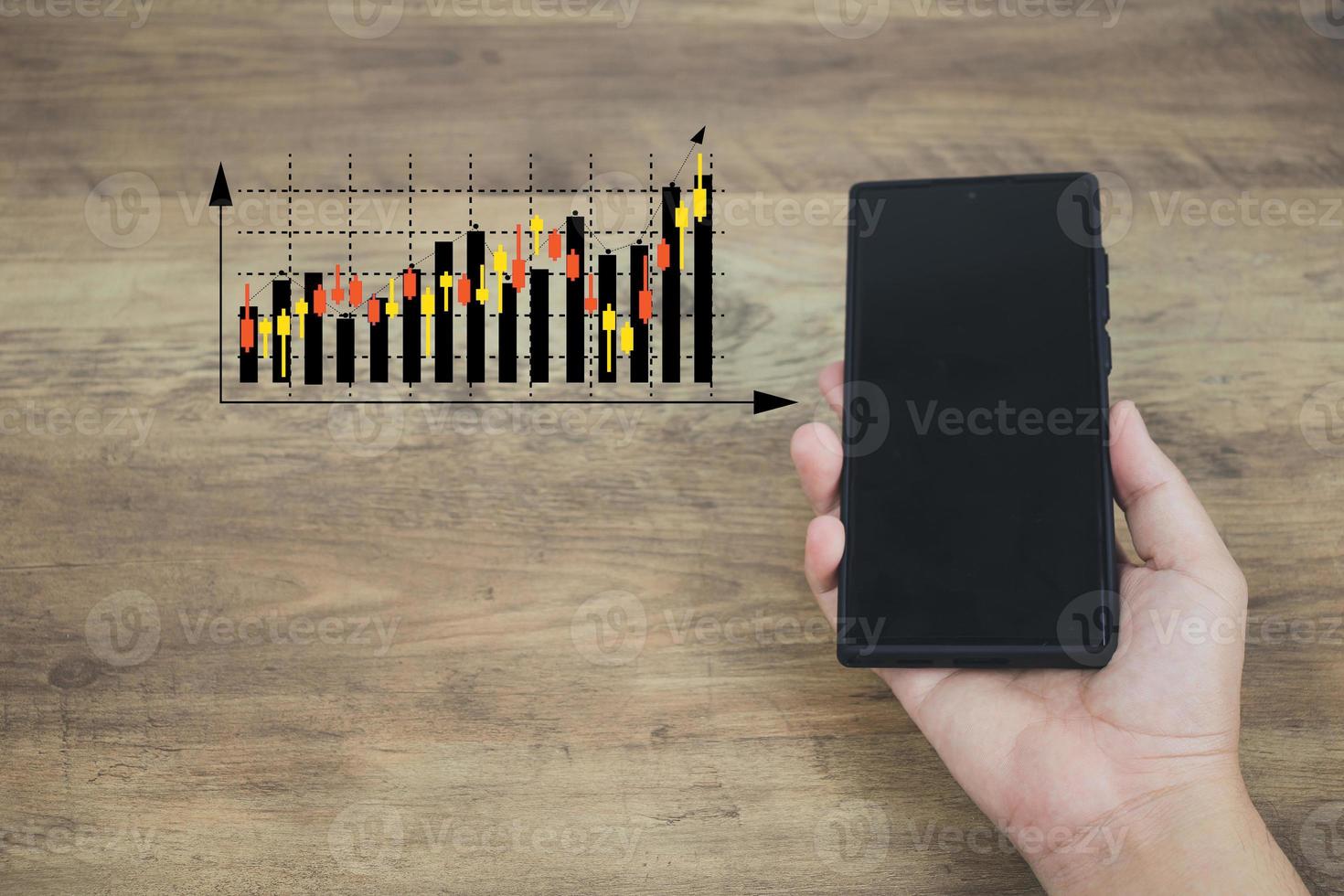 concepto de tecnología financiera y de inversión las manos de los hombres son un teléfono inteligente activo para planificar el análisis de gráficos de acciones para invertir en los mercados financieros. la otra mano tiene una imagen virtual como un gráfico de velas japonesas. foto