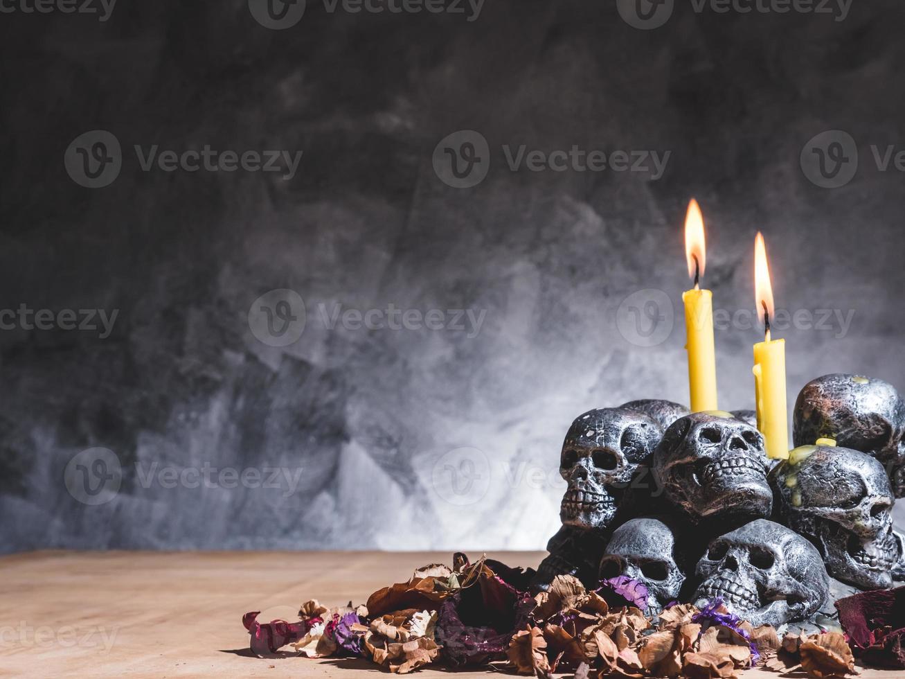 Skulls with candle burning and dried flowers on dark background. photo