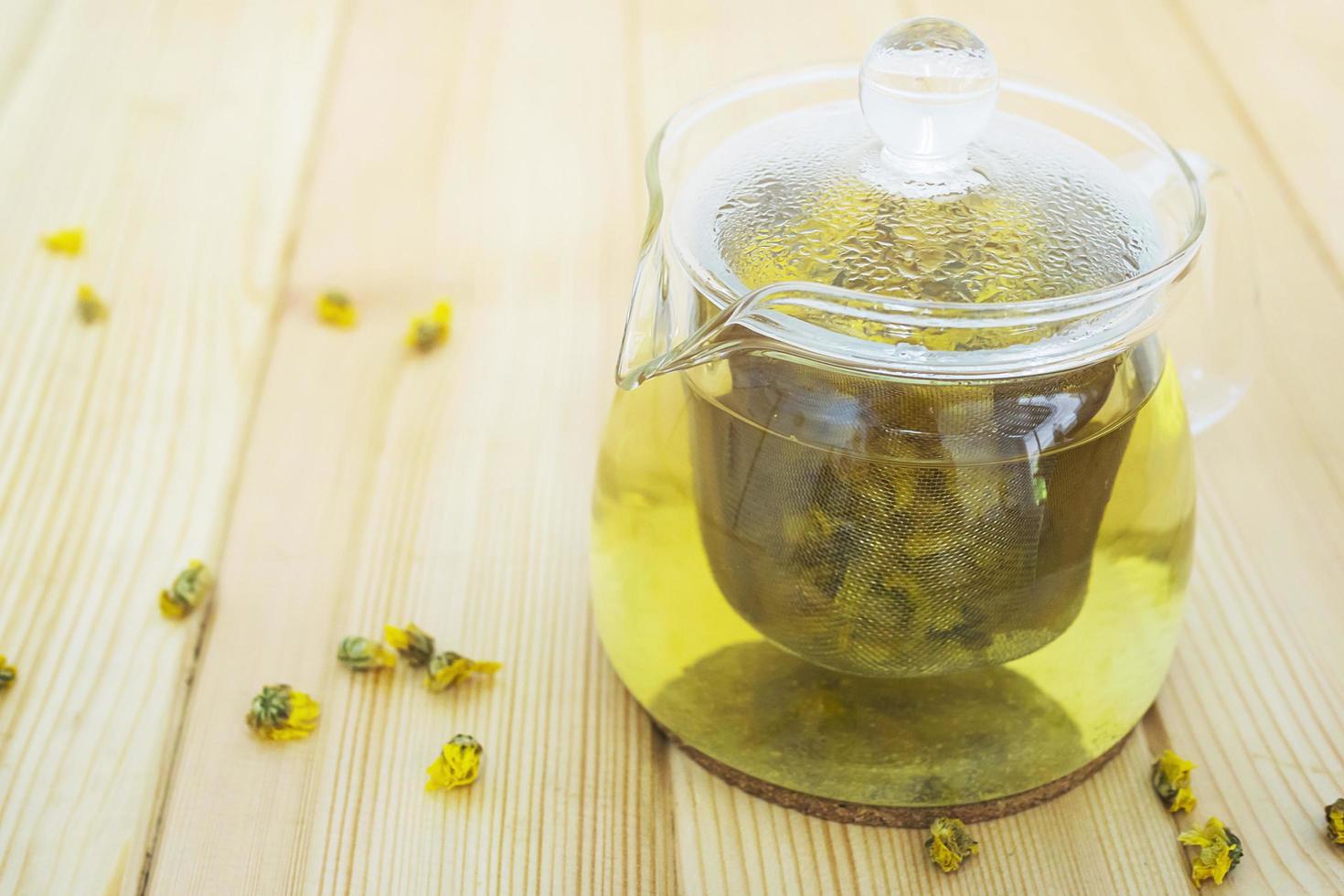 Hot jar of Chrysanthemum ready for drinking on wooden table photo