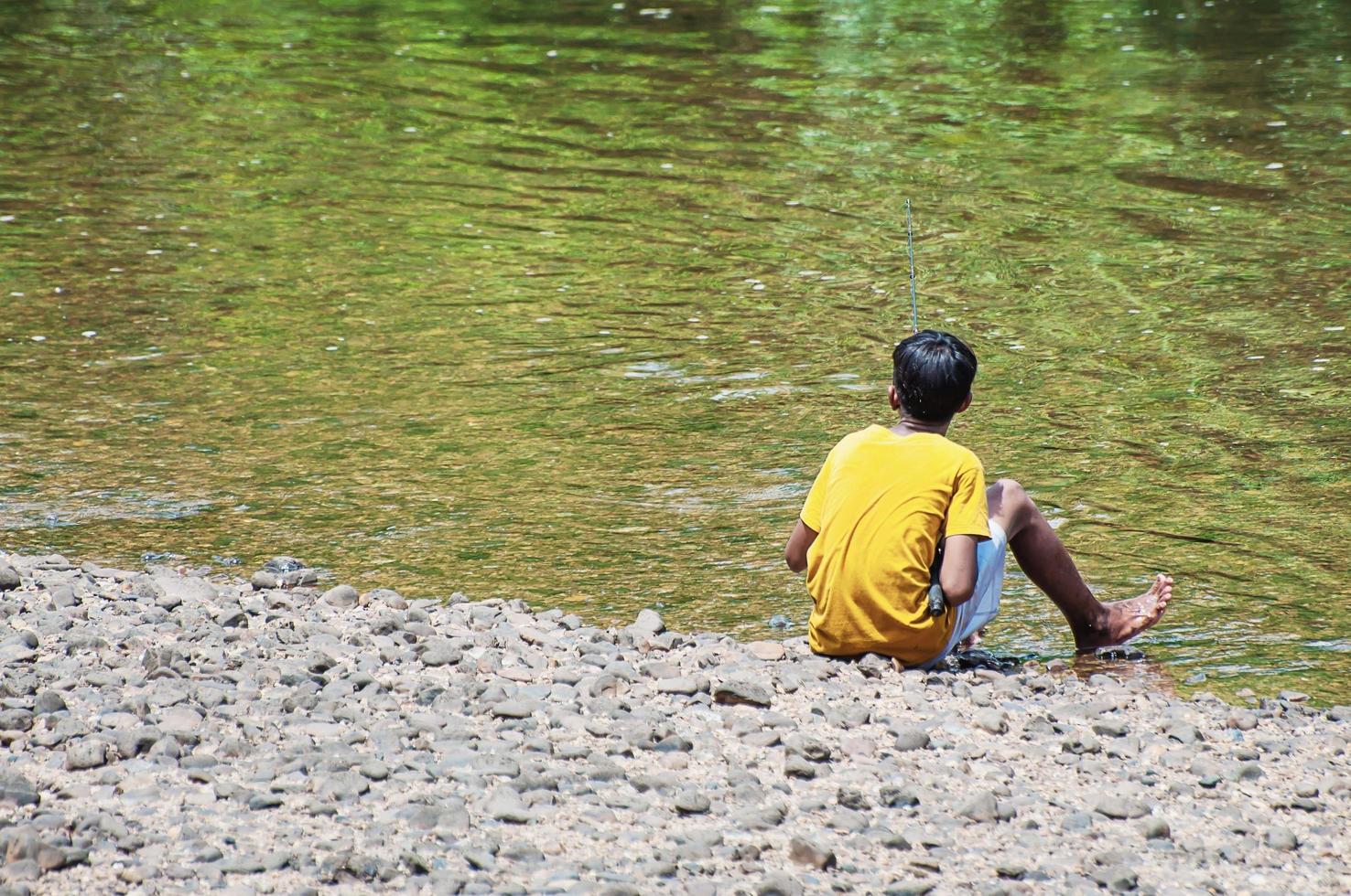 yellow kid standing and fishing photo