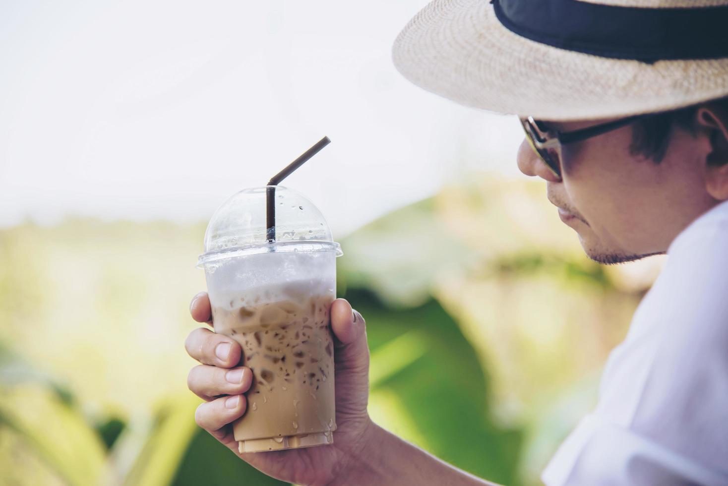 Casual Asian man drink ice coffee happily in nature - people with coffee in nature concept photo