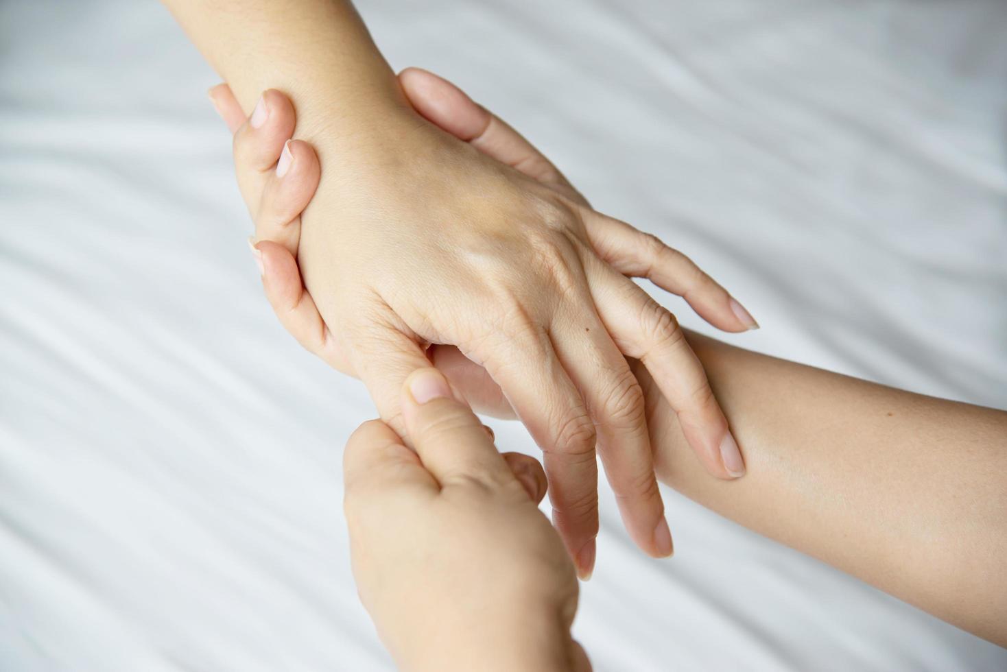 Hand spa massage over clean white bed background - people relax with hand massage service photo