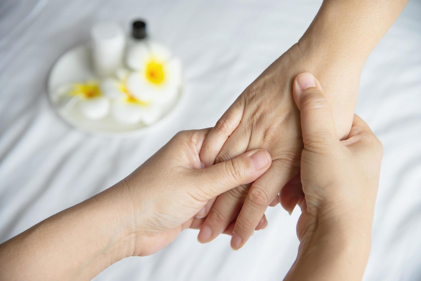 Hand spa massage over clean white bed background - people relax with hand massage service photo