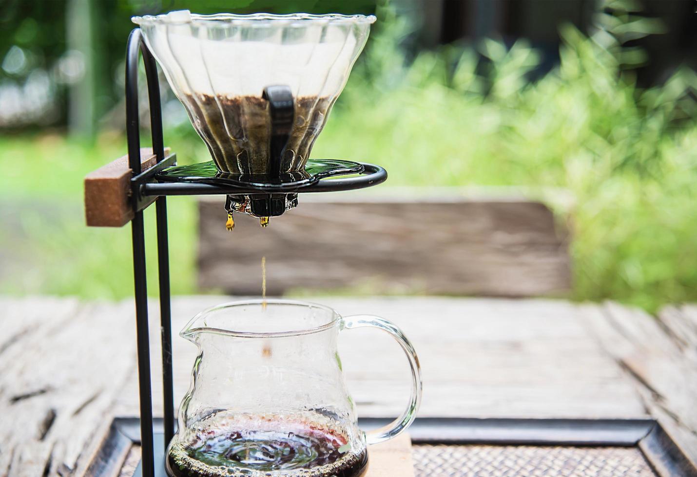 Making drip coffee in vintage coffee shop with green garden nature background - fresh coffee in nature concept photo