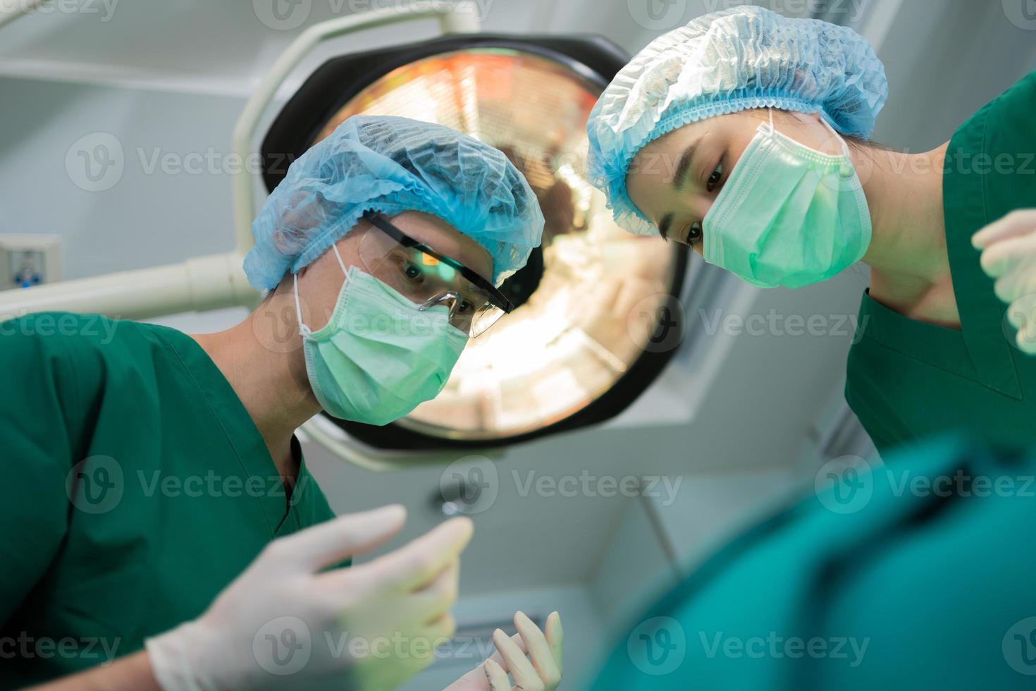 Low Angle Shot of Professional surgeons team performing surgery in operating room, surgeon, Assistants, and Nurses Performing Surgery on a Patient, health care cancer and disease treatment concept photo