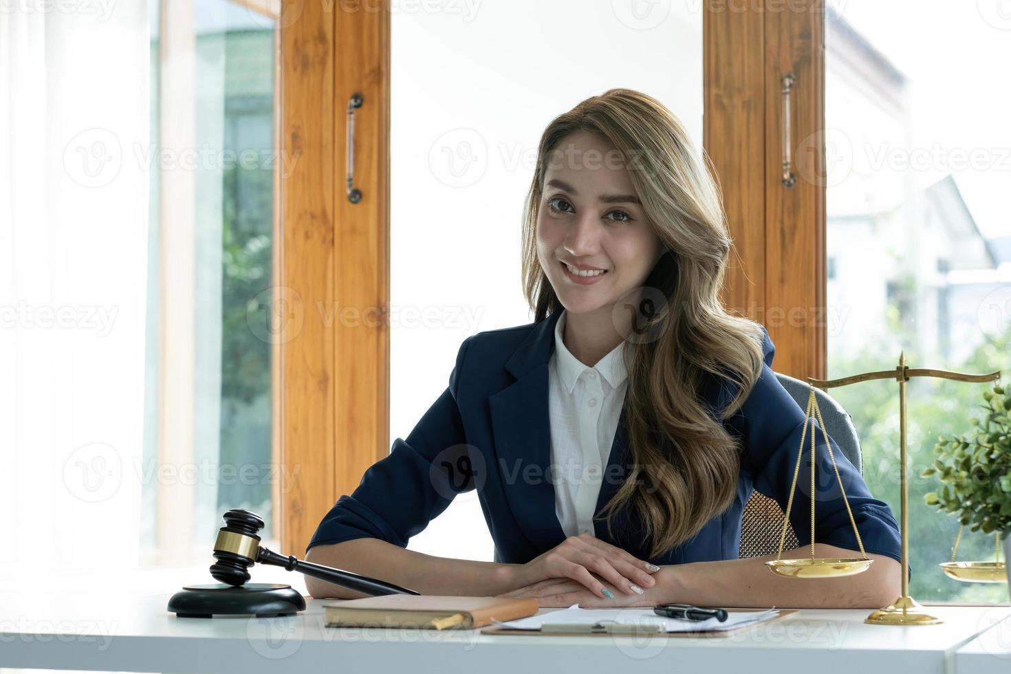 retrato, atractiva y encantadora joven mujer de negocios asiática o directora ejecutiva sentada en su escritorio de oficina en una moderna y luminosa sala de oficinas. foto