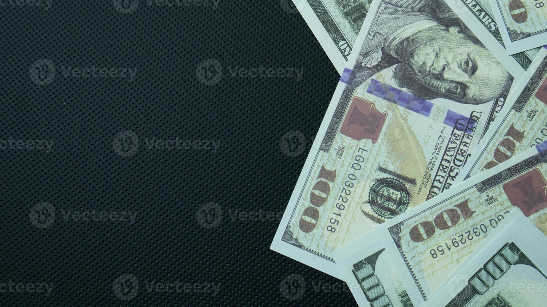 The 100 dollar banknote on black background for business content photo