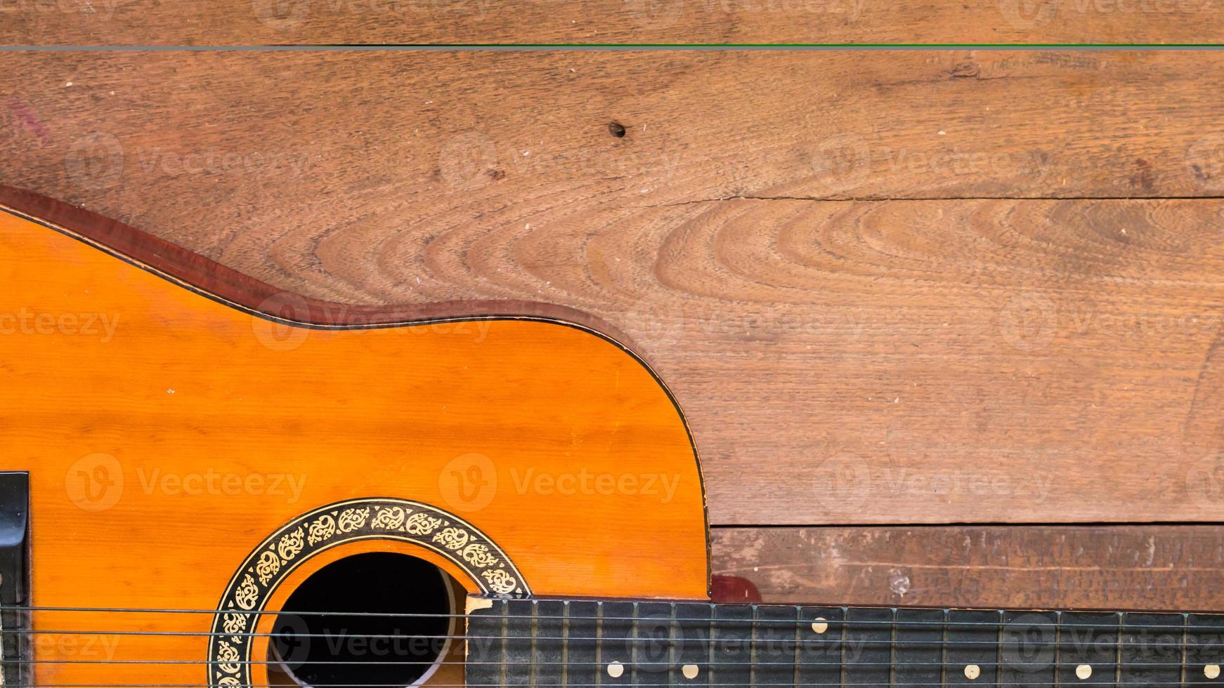 Top view workspace with acoustic guitar on wooden table background . photo