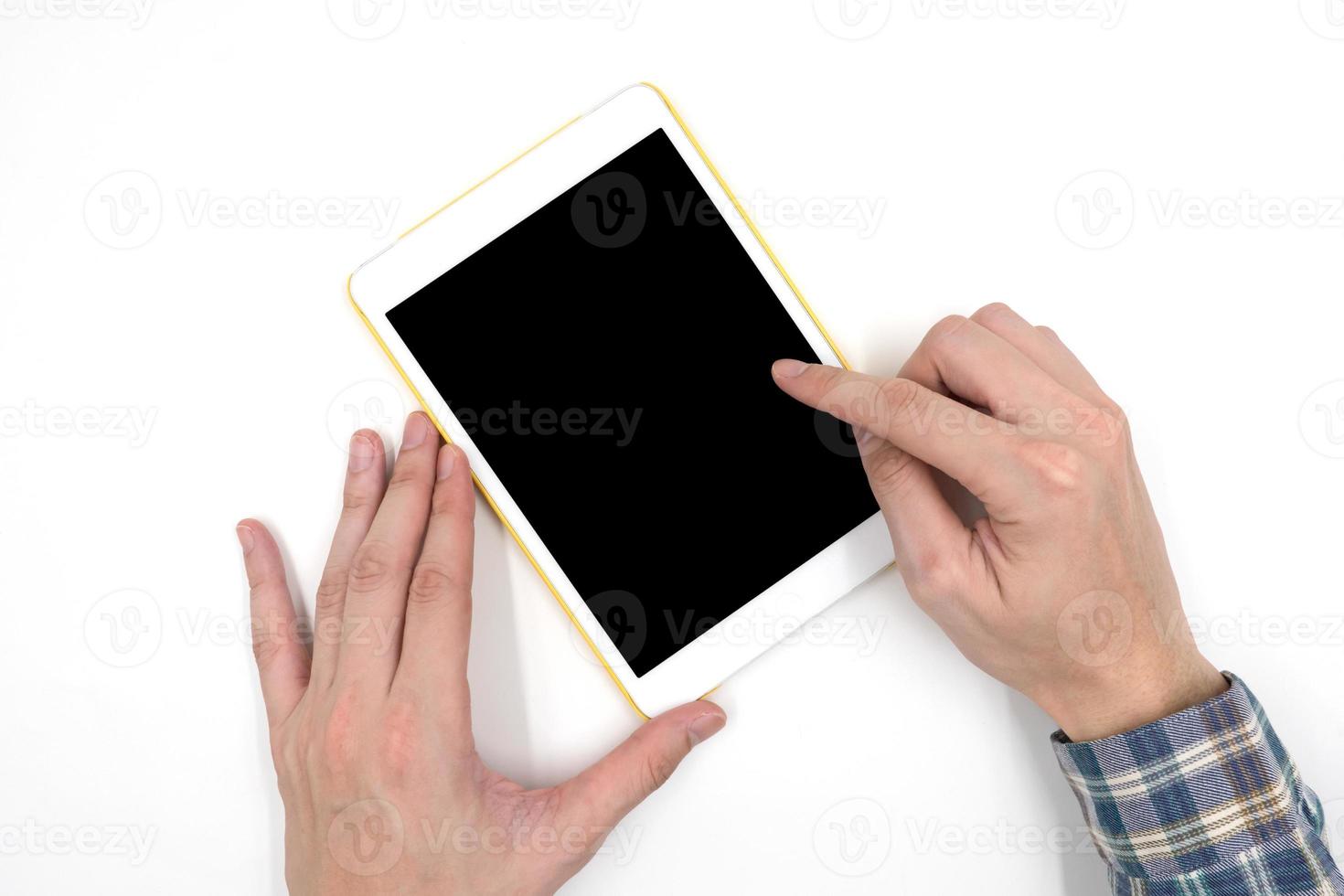 Male hands with a white tablet touch computer gadget with touch blank black screen on white background. photo