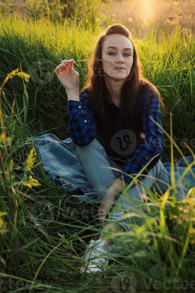 Portrait of a beautiful young woman on meadow photo