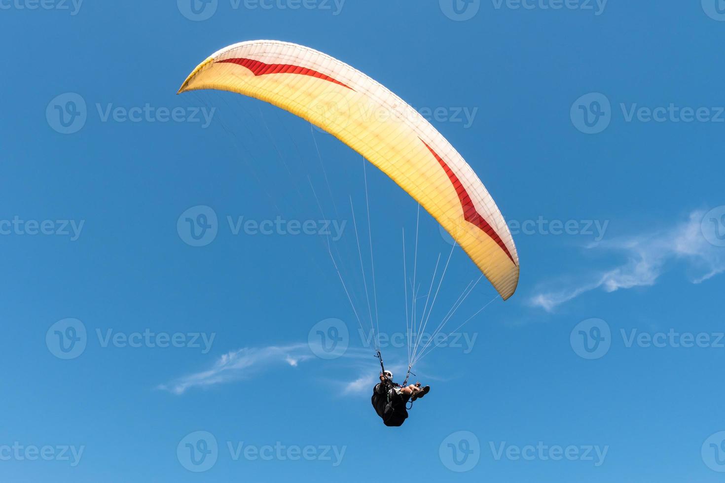 Paraglider flying in blue sky. photo