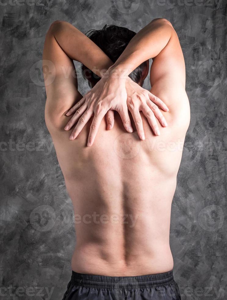 a man with back pain on grey background photo