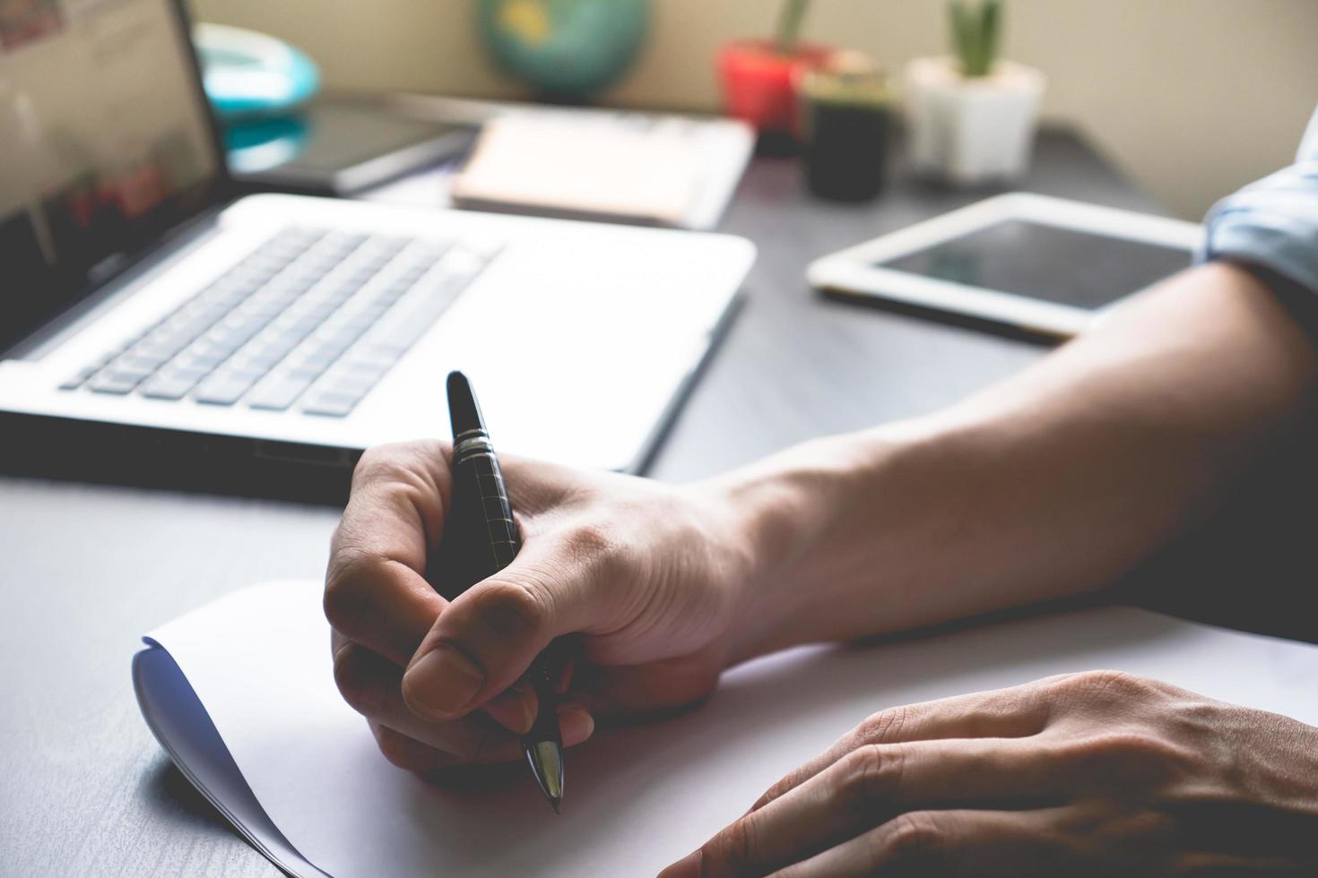 Close up of male hands writing on paper on his office desk. photo