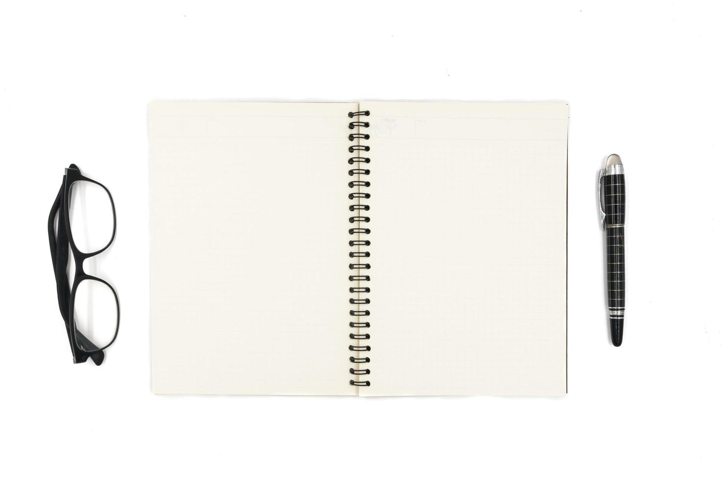 Top view of Notebook with pen and glasses on white background. photo