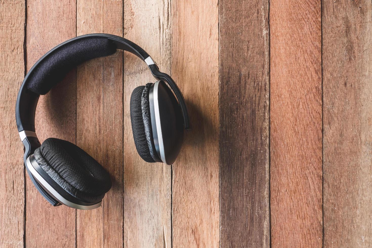 vista superior de los auriculares sobre fondo de mesa de madera. espacio libre para texto foto