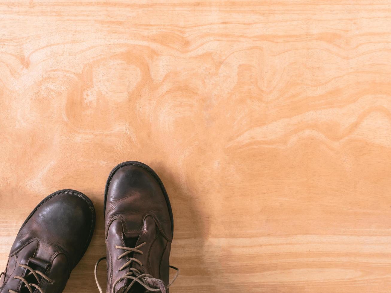 Brown leather men's boots on wooden table background, free space for text photo