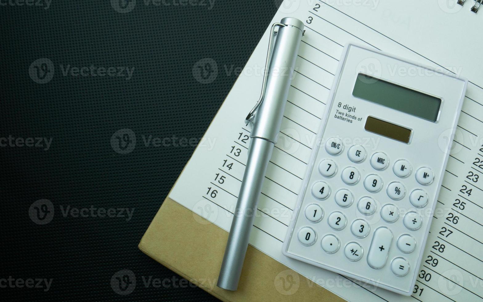 The white calculator on black background for business content. photo