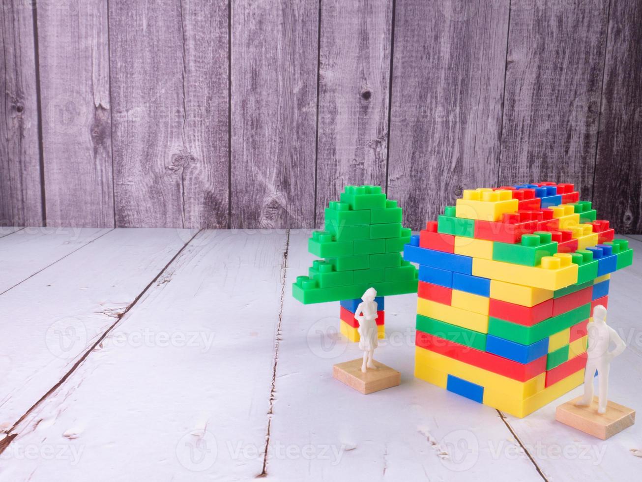 ladrillo de juguete multicolor en casa y figura blanca para niños o concepto de negocio de propiedad foto