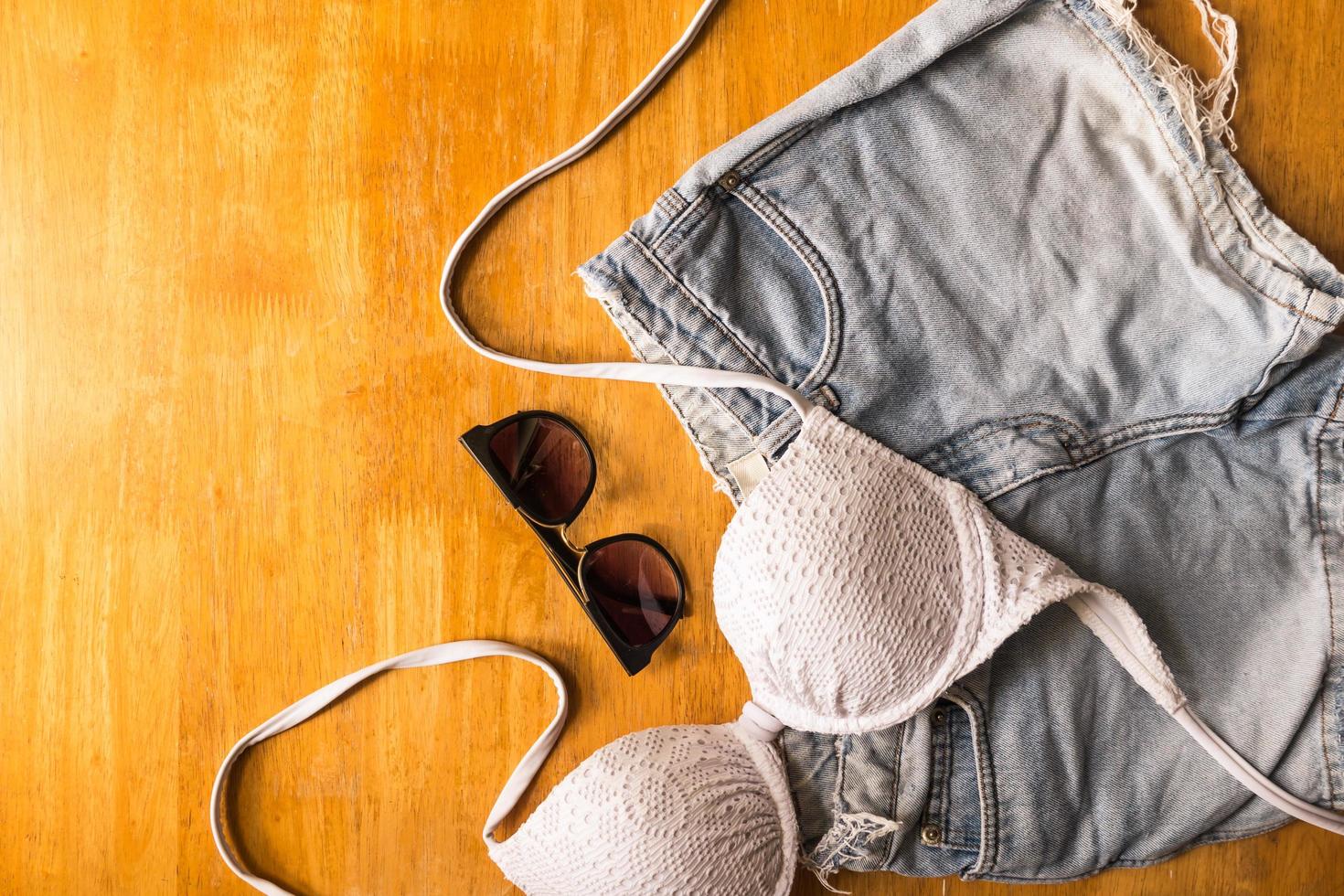 Top view of Summer clothes and accessories for woman on wooden table. Vacation concept photo