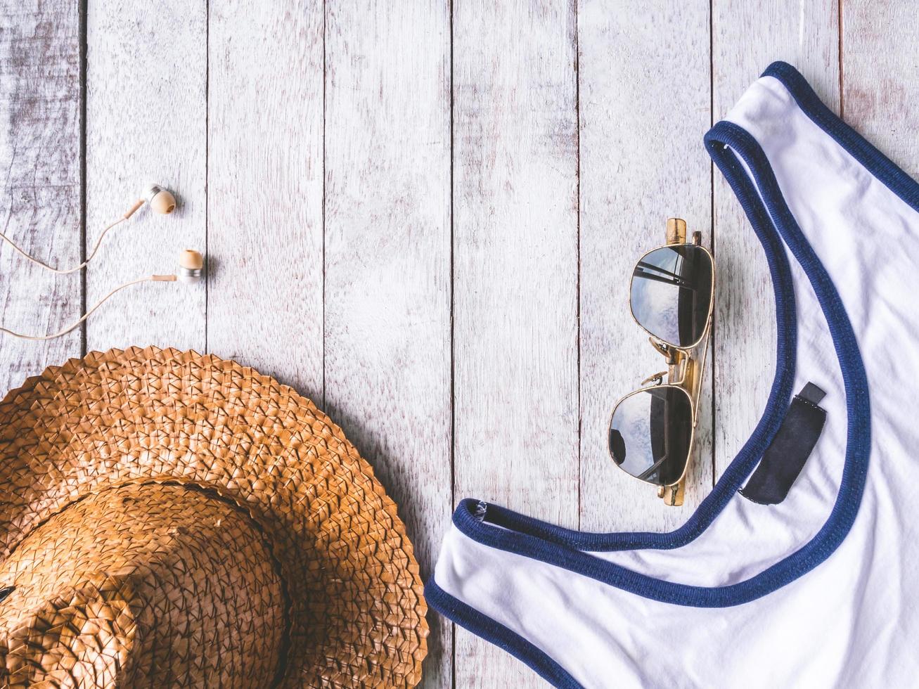 Top view of male summer accessories, clothes and gadgets on the wooden background. photo