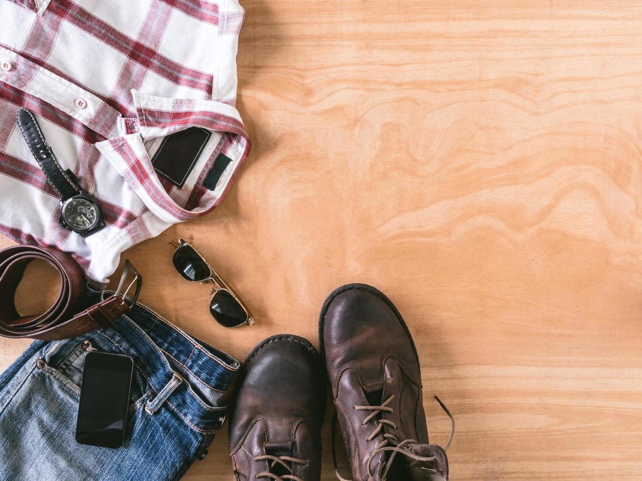 Top view of Men's casual outfits with accessories on wooden table background photo