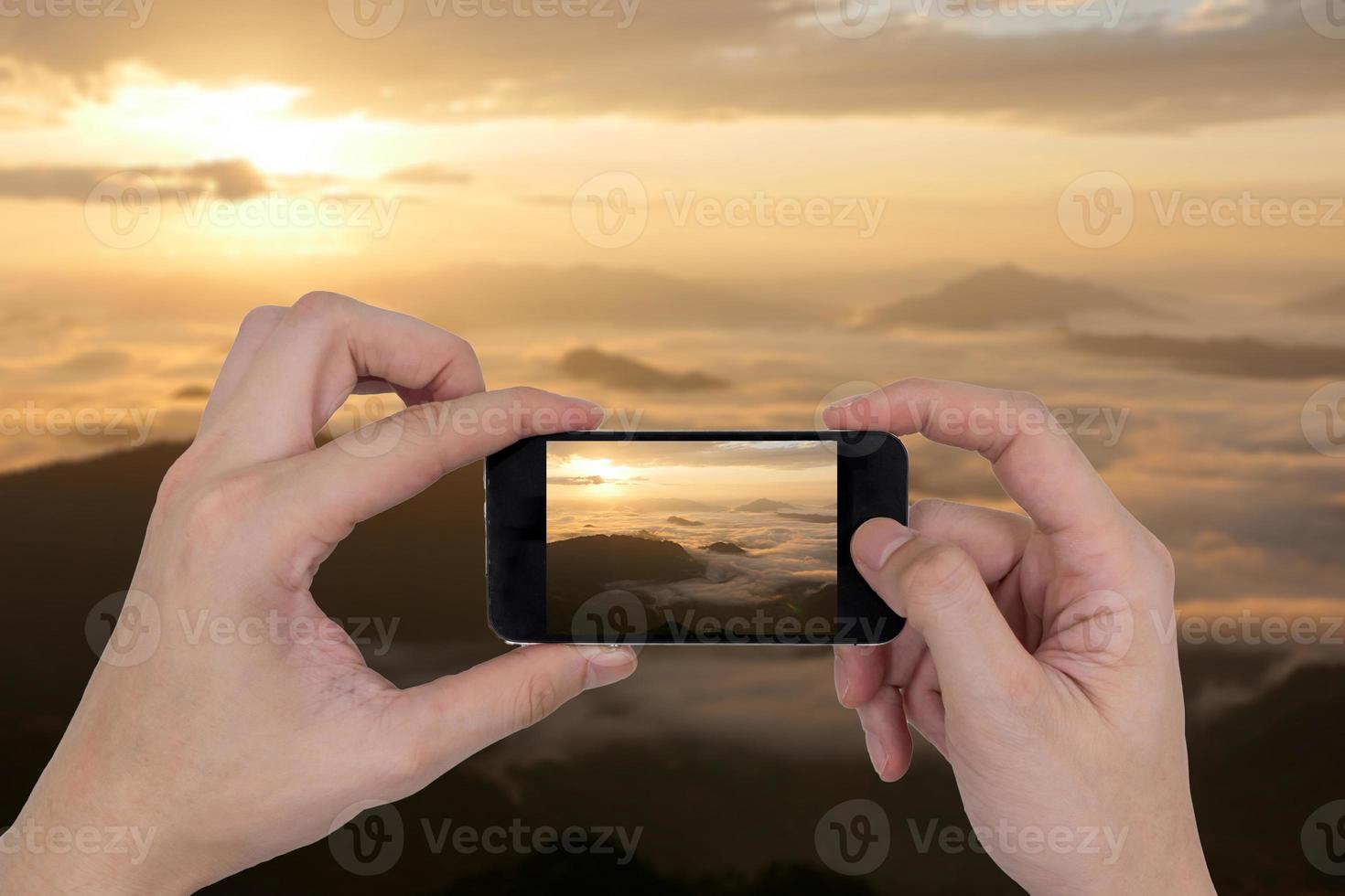 Male hands holding smartphone taking picture of mountain landscape. photo
