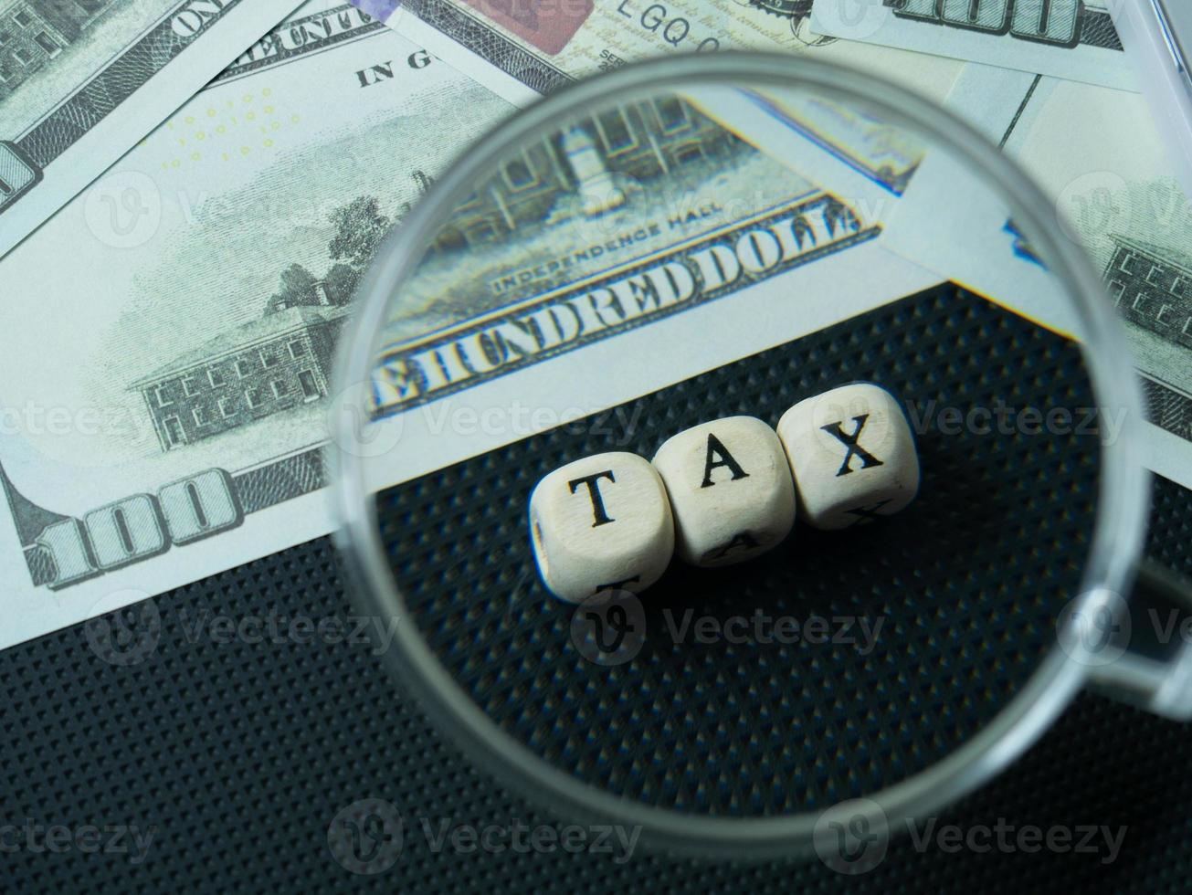 The Magnifying glass and tax wood cube for business content photo