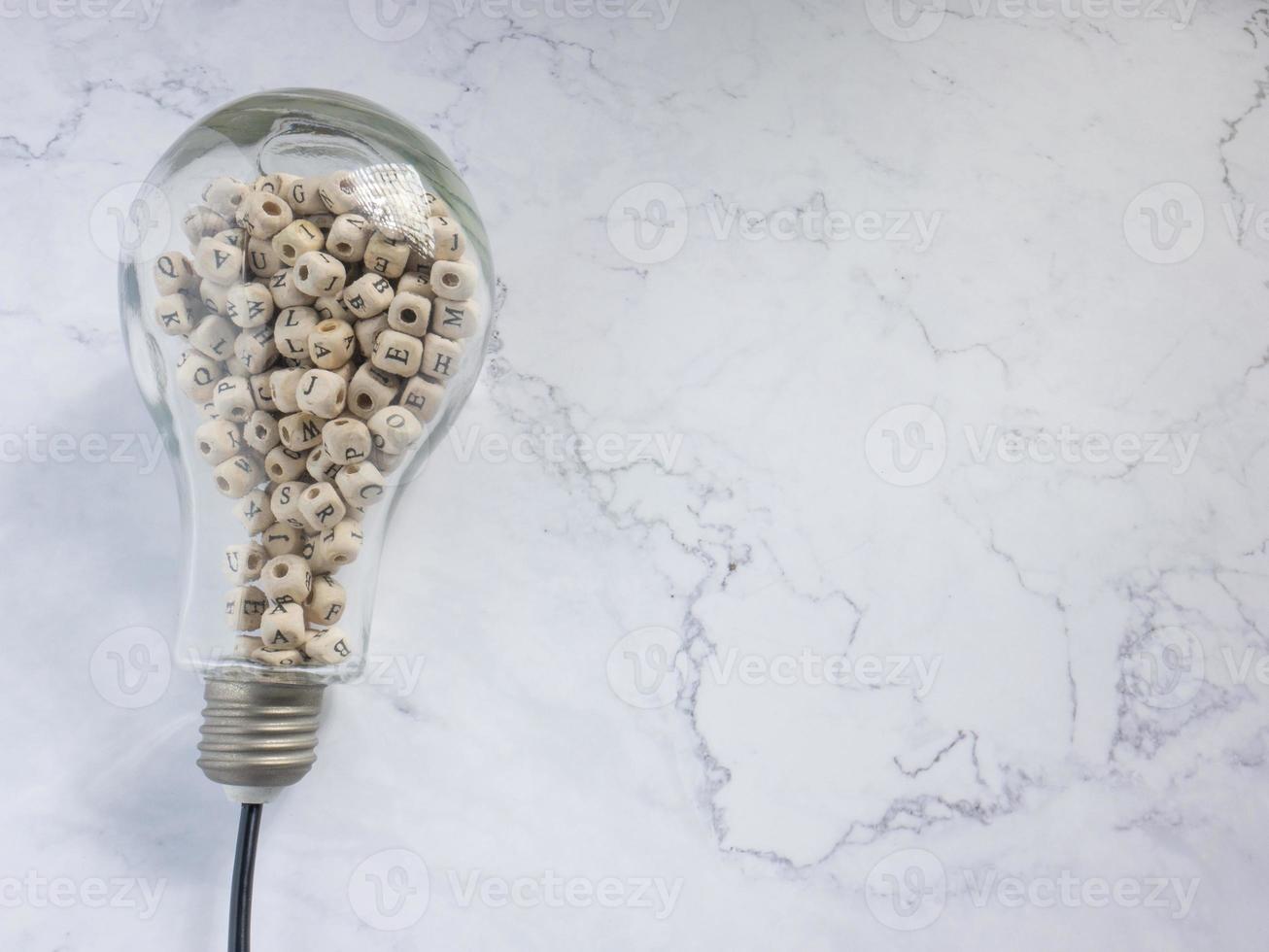 light bulb and alphabet wood cube on white marble for idea or think concept photo