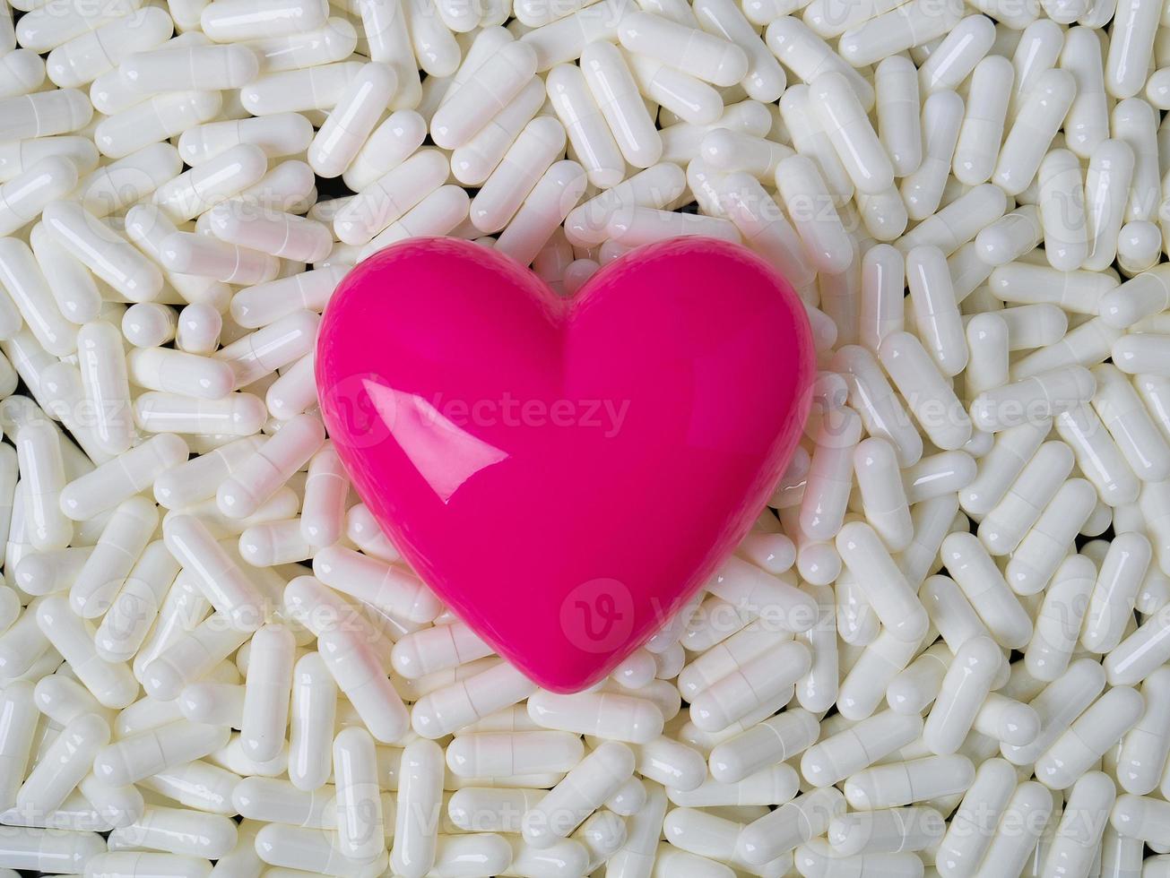 The heart  and white capsules image  for  sci or medical content. photo