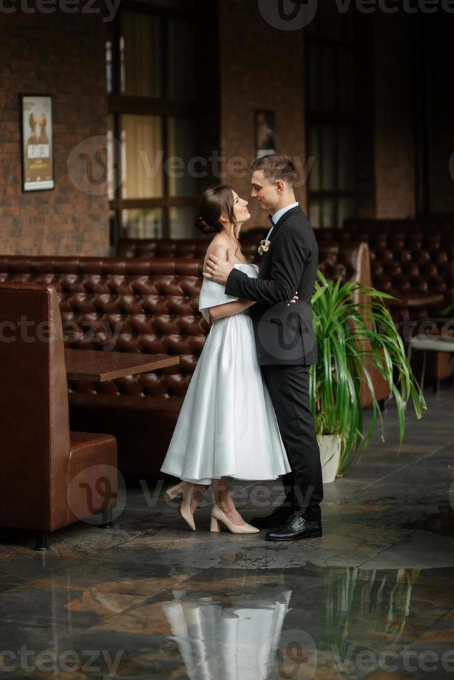 young couple bride and groom in a white short dress photo