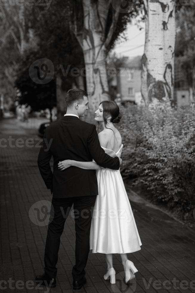 young couple bride and groom in a white short dress photo