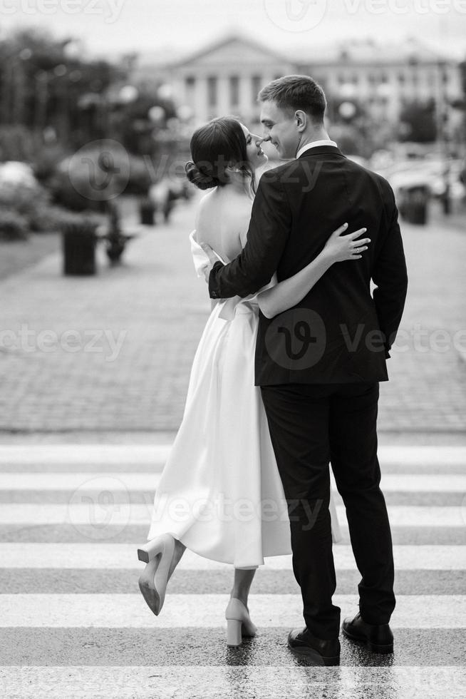 young couple bride and groom in a white short dress photo