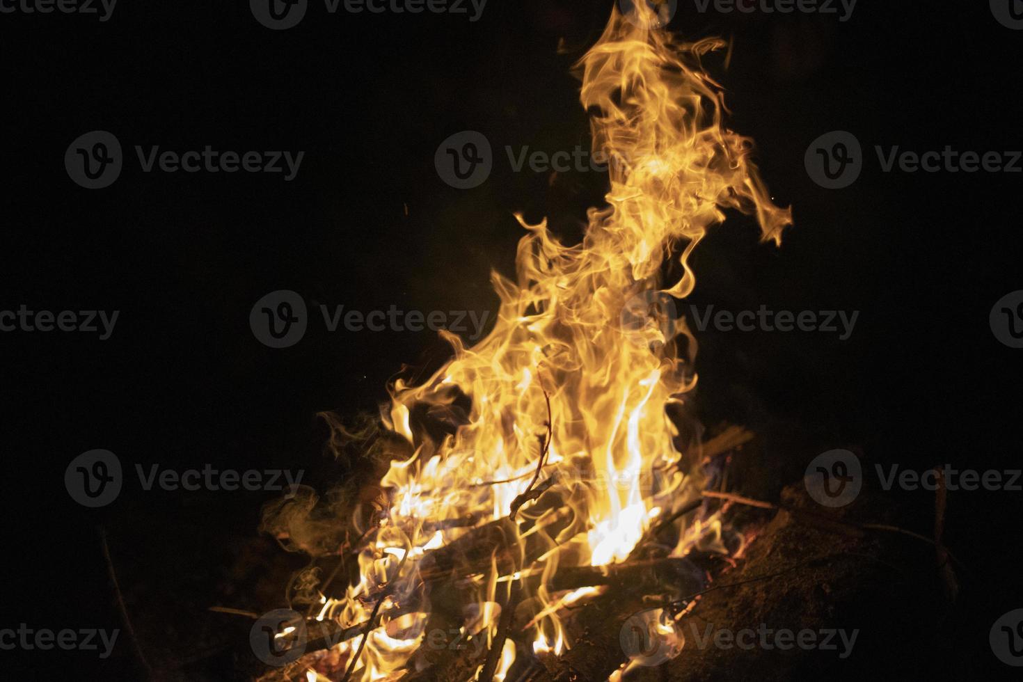 hoguera en la oscuridad. llamas en la noche. Quemando madera. detalles de acampada foto