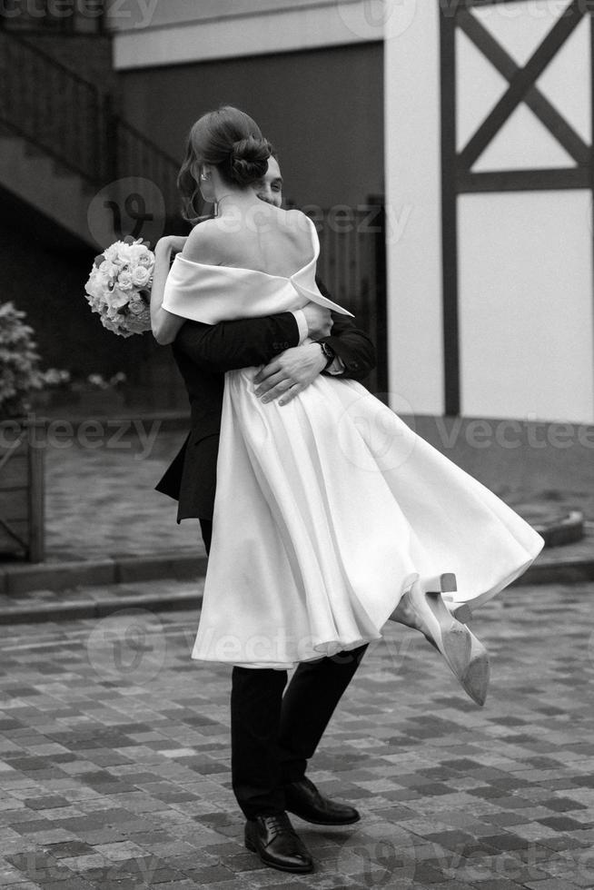 young couple bride and groom in a white short dress photo