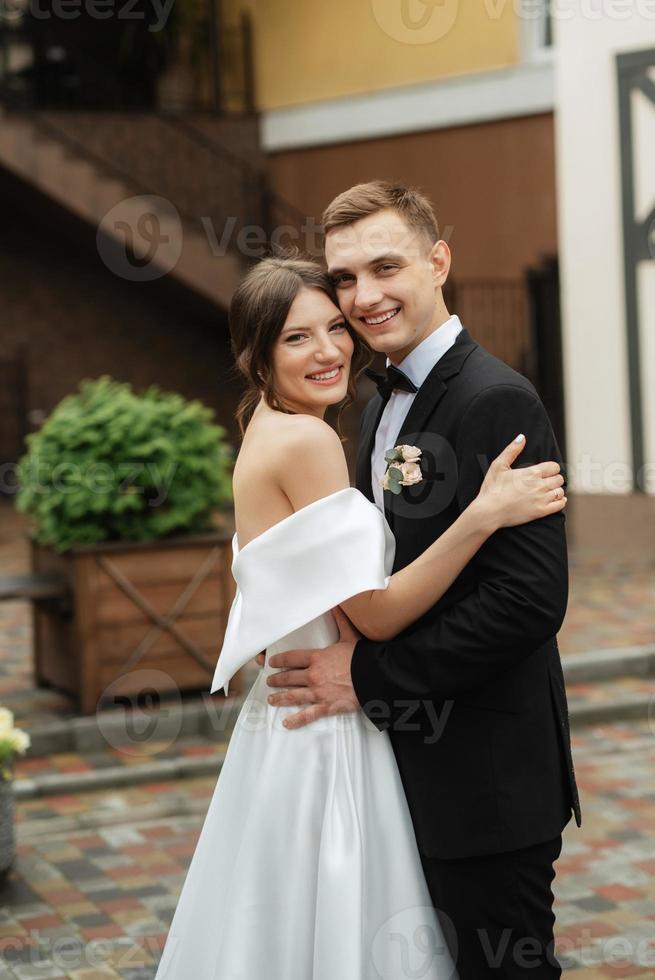 young couple bride and groom in a white short dress photo