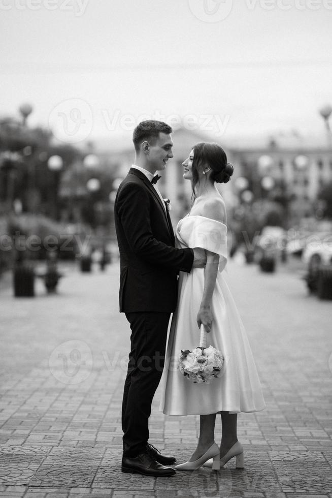 young couple bride and groom in a white short dress photo