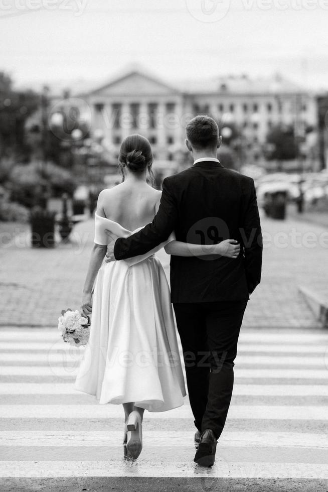 young couple bride and groom in a white short dress photo