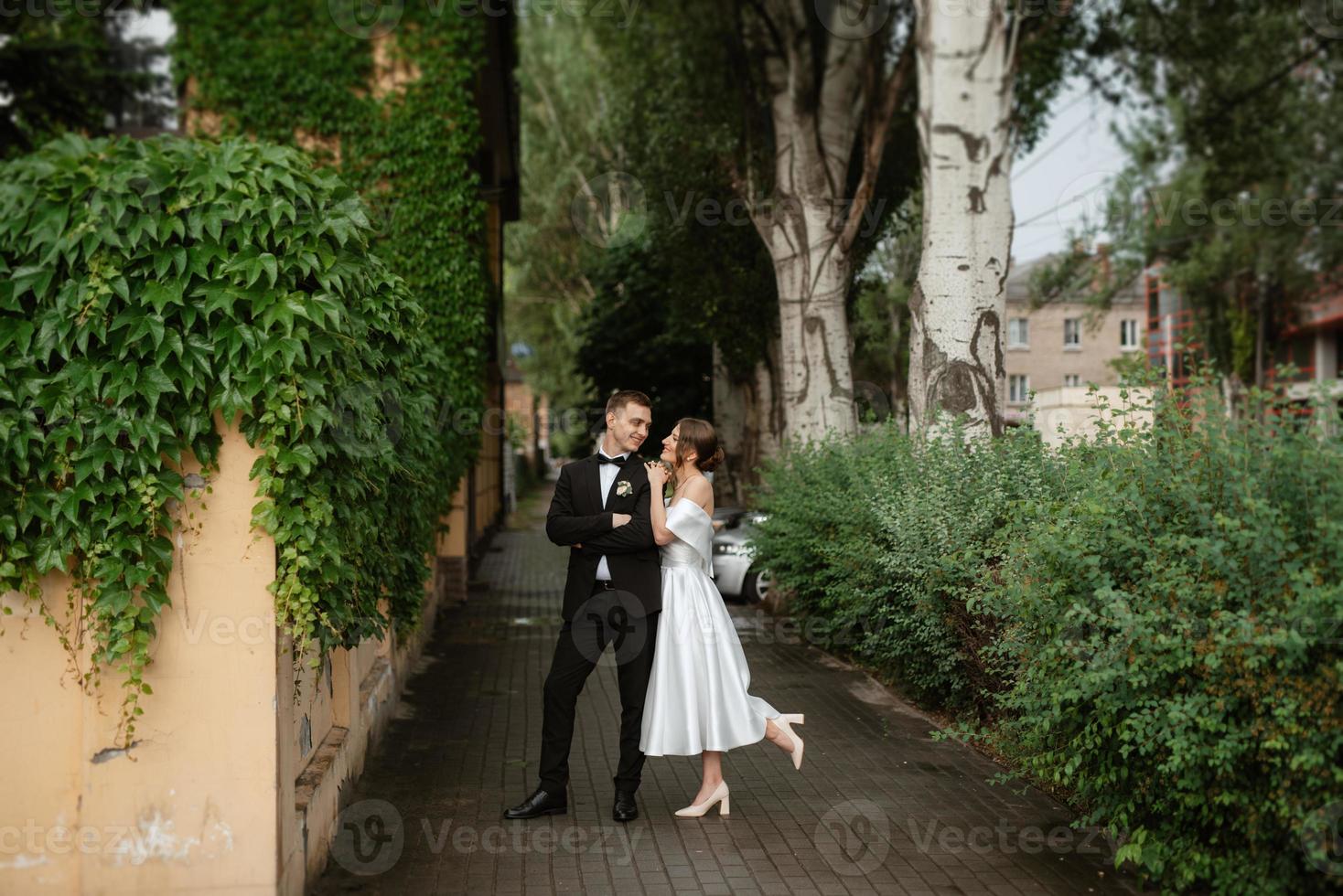 young couple bride and groom in a white short dress photo