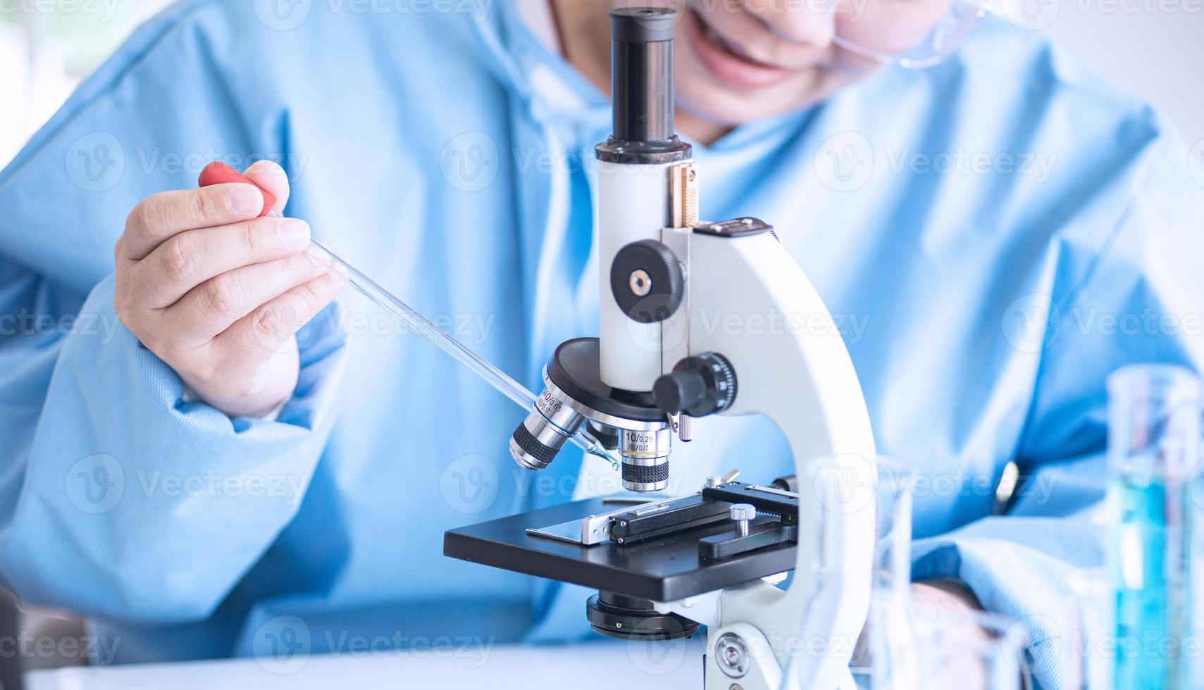 Asian woman scientist, researcher, technician, or student conducted research or experiment by using microscope which is scientific equipment in medical, chemistry or  biology laboratory photo