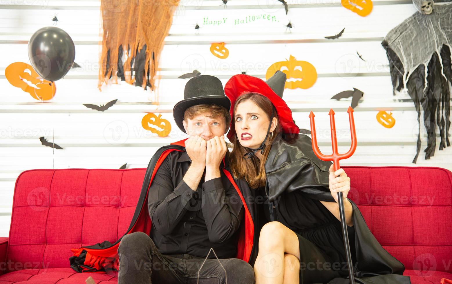 Happy Halloween party concept. Young man and woman wearing as vampires, witch or ghost celebrate the halloween festival photo