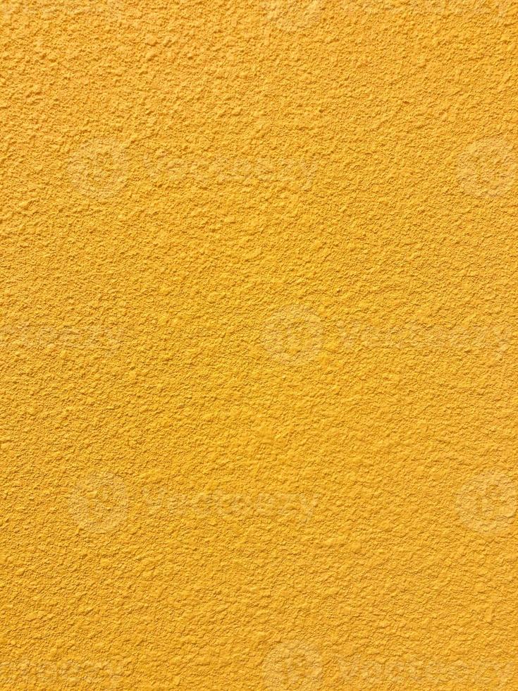 Golden yellow stone grain wall spray painted texture concrete background in retro style with copy space photo