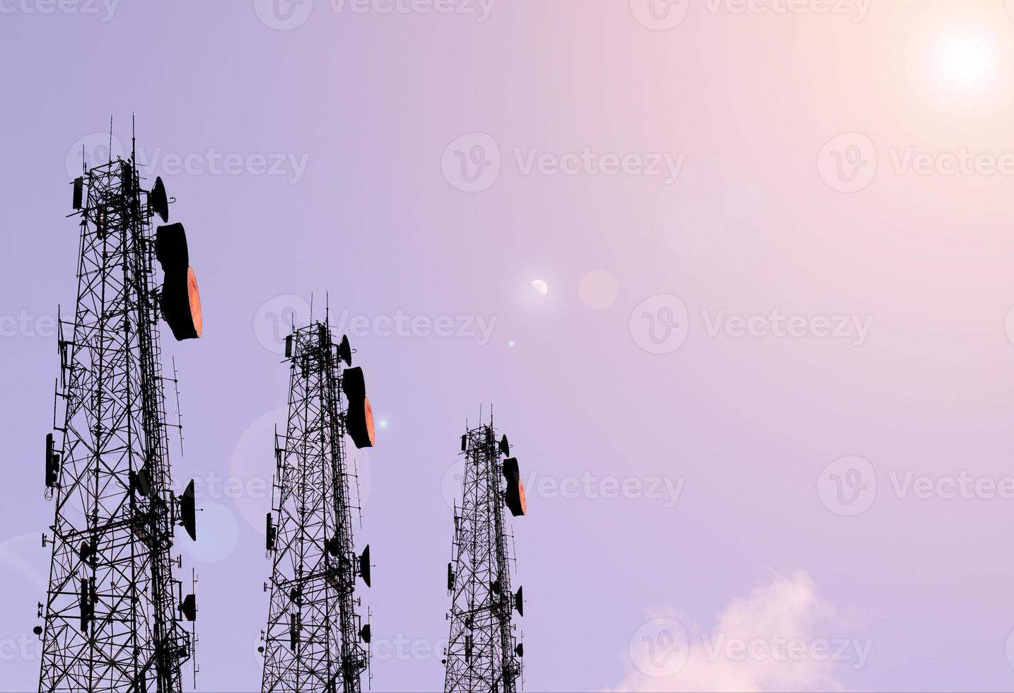 Saturday, telecommunication signal, three towers, facing data signal in the evening, receiving the light of the sunset and having a Lens Flare with small clouds. There are stars that are not clear photo