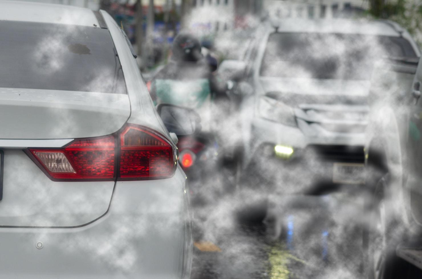 contaminación del automóvil escape de humo contaminación del automóvil atasco de tráfico en la carretera. automóvil que emite dióxido de carbono que causa la contaminación del aire. foto